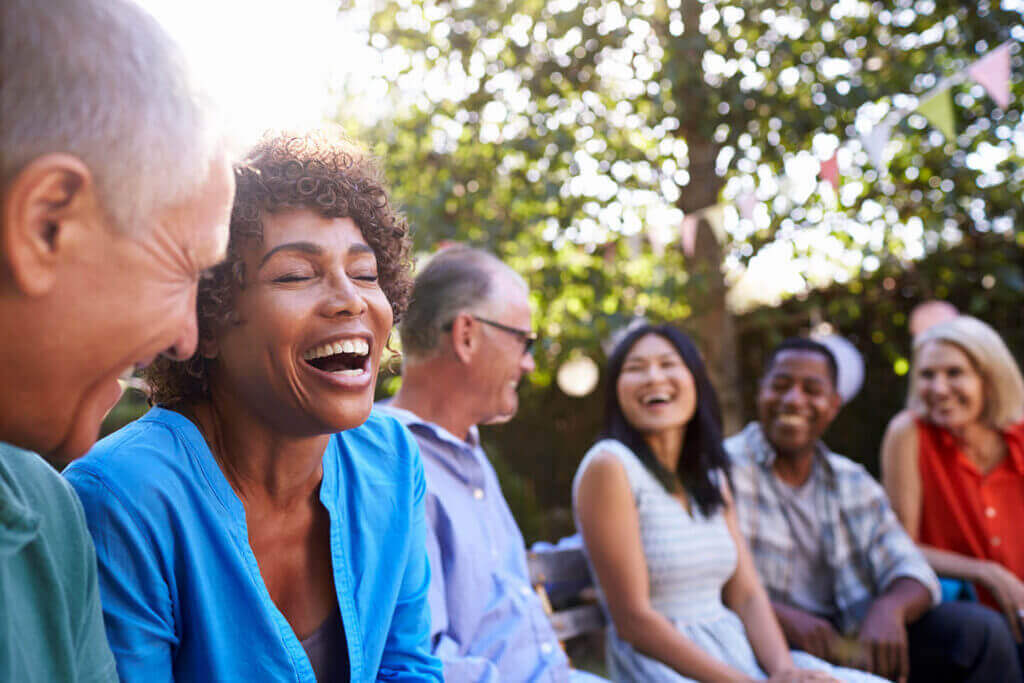 Group of older people laughing in backyard