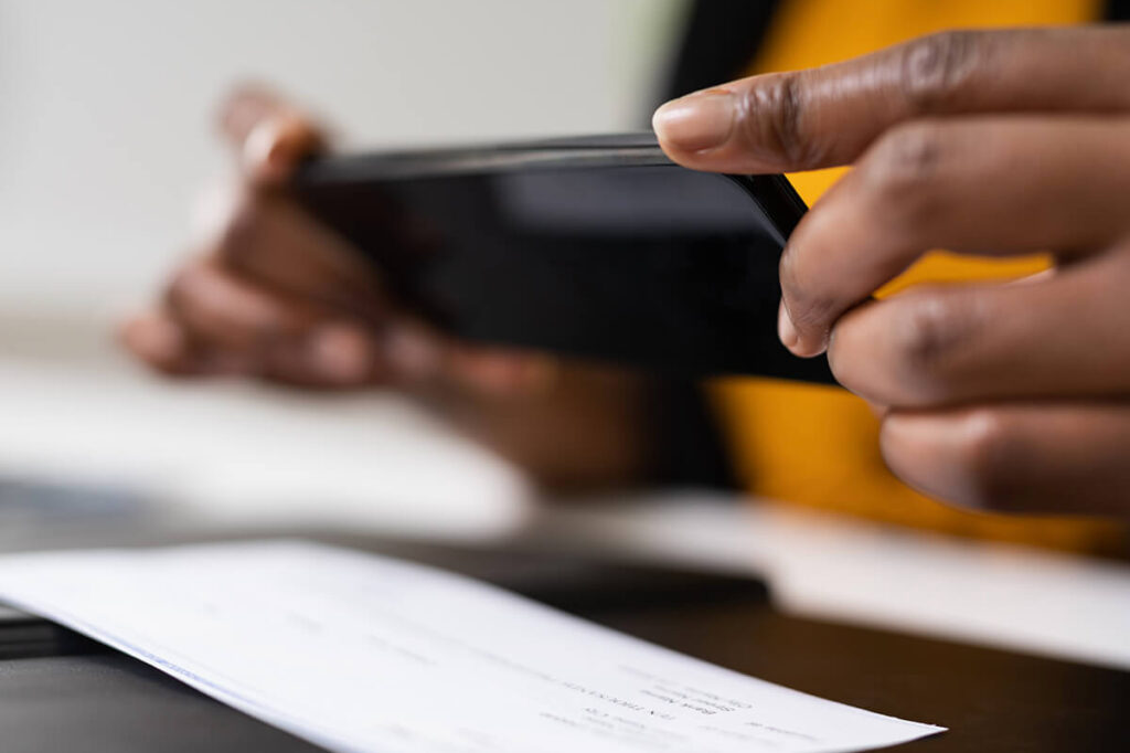 Person using a smartphone to take picture of check to send to bank for mobile deposit.